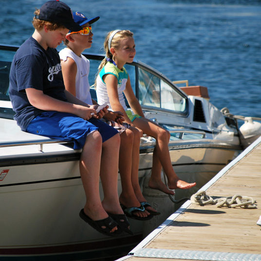 Kids sitting on boat at dock